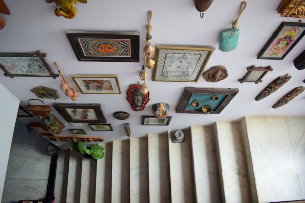 A gallery wall with art, masks and some odds and ends